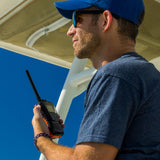 Man on boat holding Cobra Marine radio