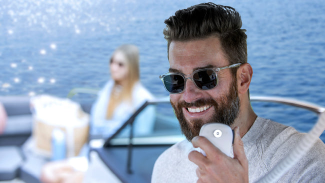 Man on boat speaks into Cobra handheld marine radio