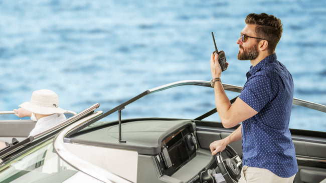 Man piloting boat speaks into Cobra marine radio