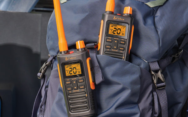 Two Cobra TrailBlazer 450 GMRS' clipped to the back of a grey backpack