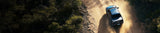 pickup truck driving along a dirt road
