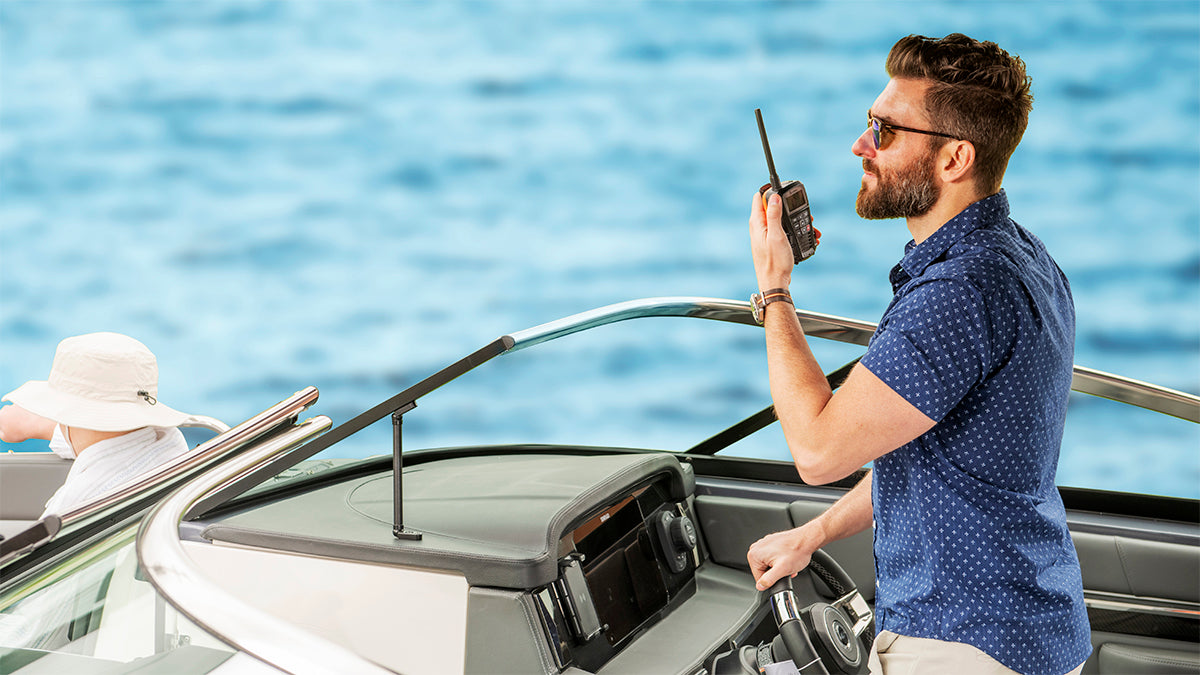 Man on a boat listens to Cobra BlueBound 150 VHF marine radio