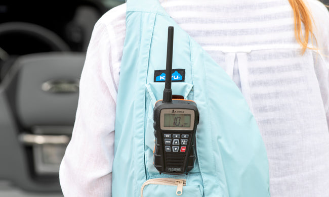Cobra BlueBound 150 VHF marine radio clipped to a light blue backpack 