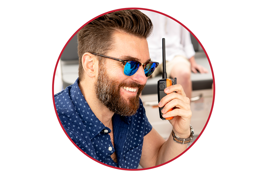 Man with sunglasses listens to Cobra BlueBound 150 VHF marine radio