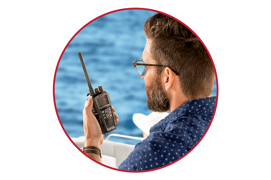 Man on a boat using a black Cobra BlueBound 350 marine radio