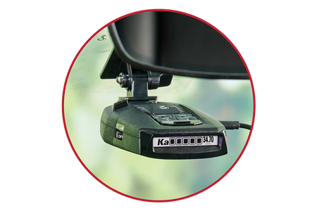 Red outline circle with Cobra RAD 490i radar detector mounted on a car windshield inside